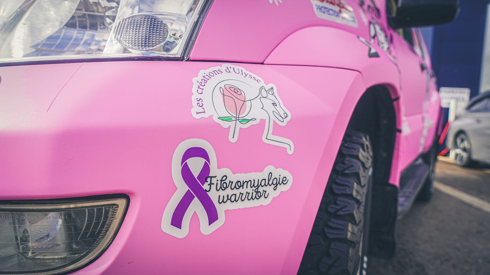 Photo d'un voiture rose avec des autocollant